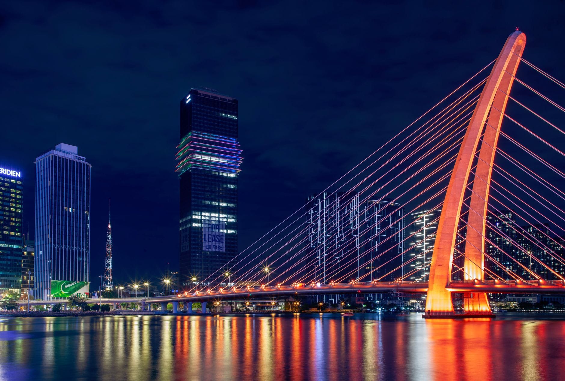 Nocny widok na oświetlony nowoczesny most i panoramę miasta nad wodą