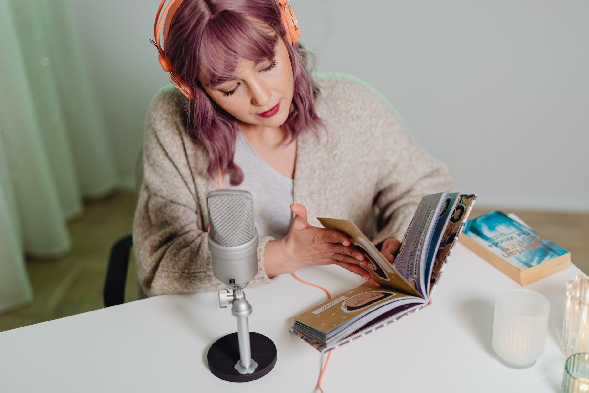 Młoda kobieta nagrywa podcast o mindfulness przy biurku z książkami